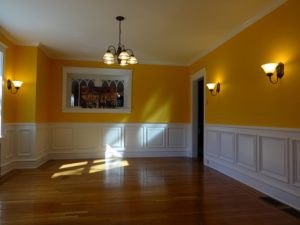 custom raised-panel wainscoting contrasting with rich, warm colors